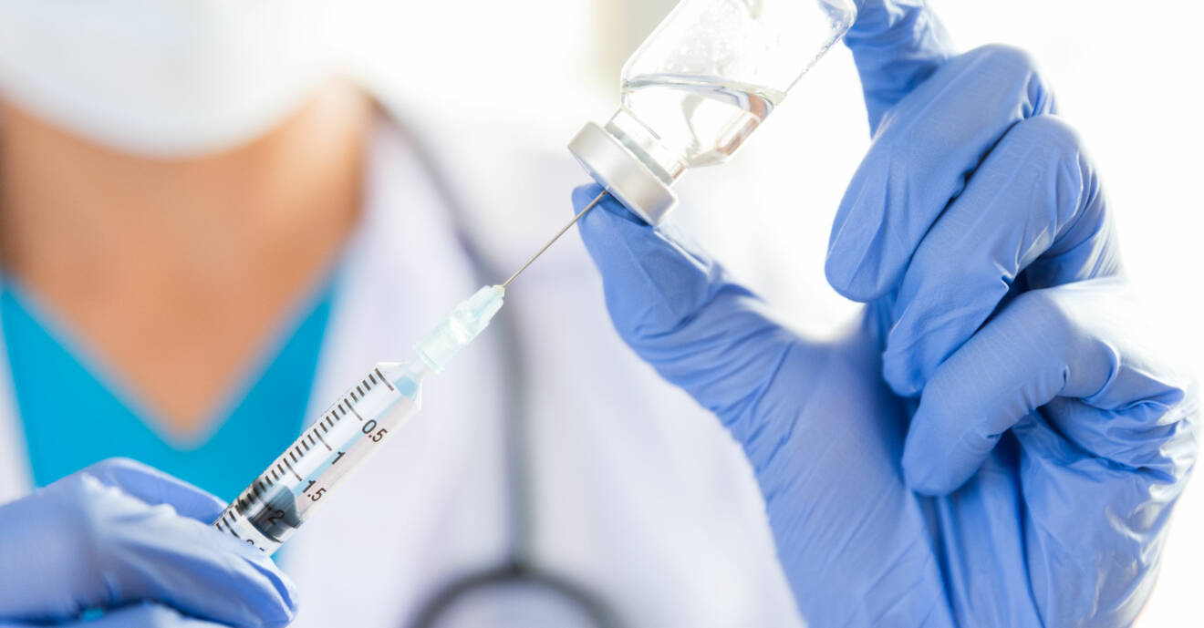 Sjukvårdspersonal fyller en spruta med något som skulle kunna vara vaccin mot covid-19.