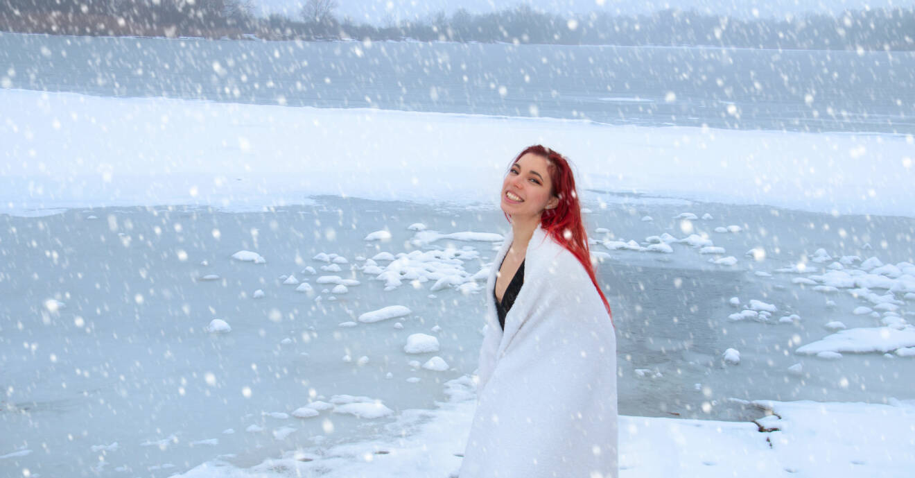 Kvinna kallbadar utomhus i vinterlandskap och snö.