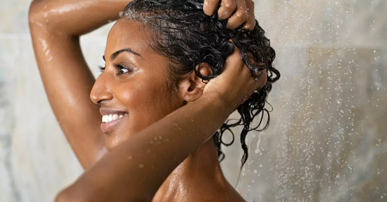 Kvinna i duschen, huskurer för håret.