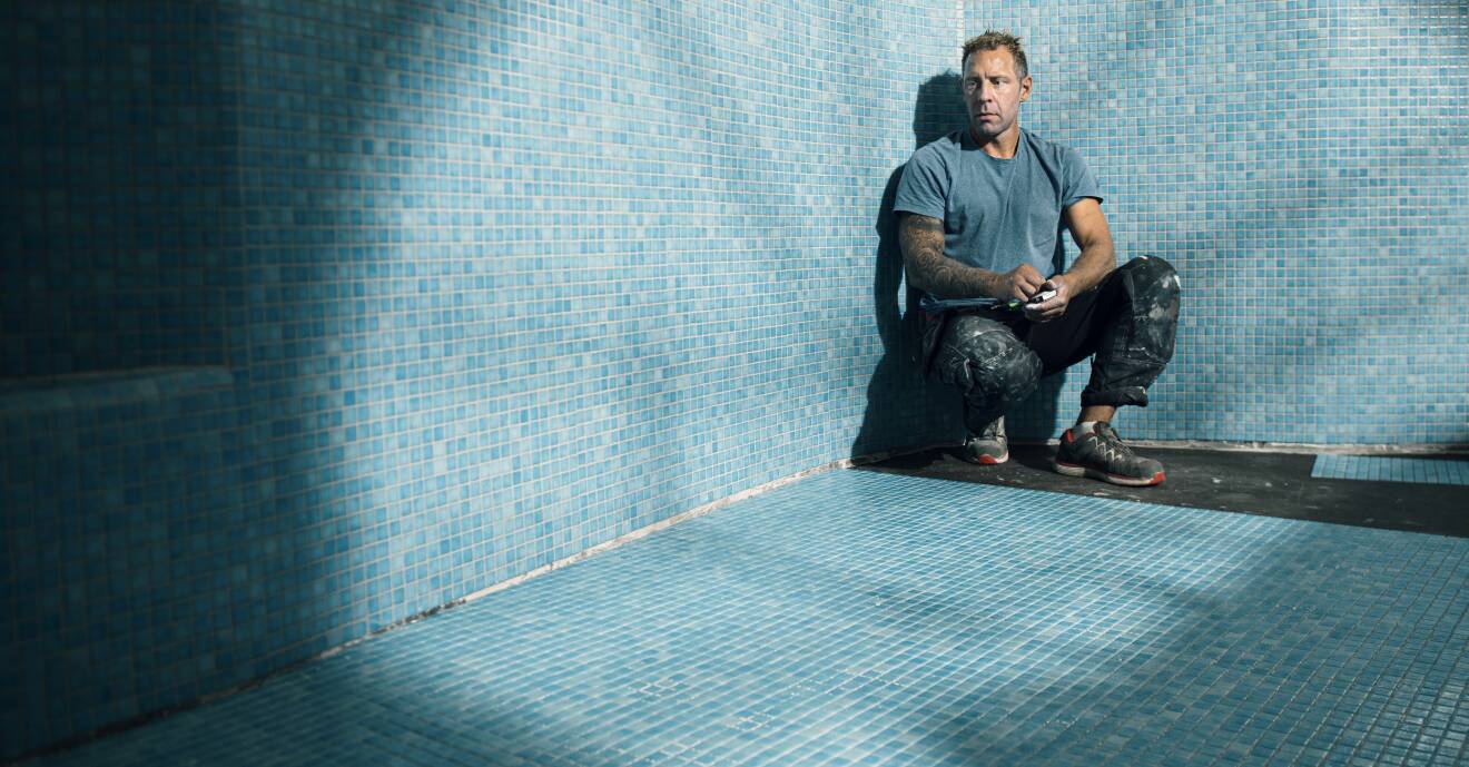 Tobias sitter i sin pool som är täckt med 140000 mosaikbitar.