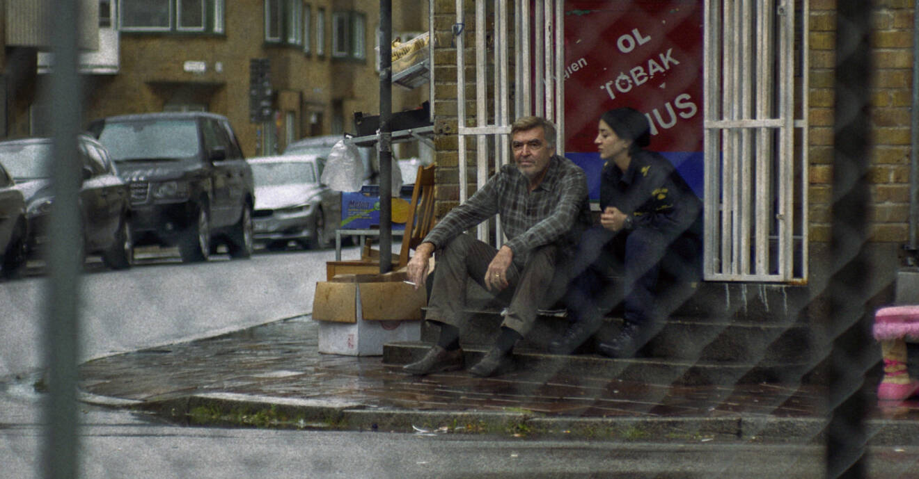 En scen från tv-serien Tunna blå linjen där polisen Leah sitter med sin morfar Jurek utanför hans lilla butik.