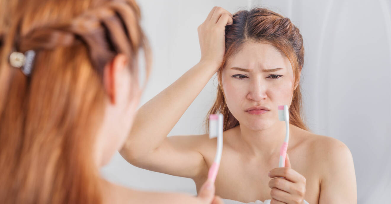 En kvinna tittar på sin tandborste efter att ha insett vilken bakteriehärd den kan vara.
