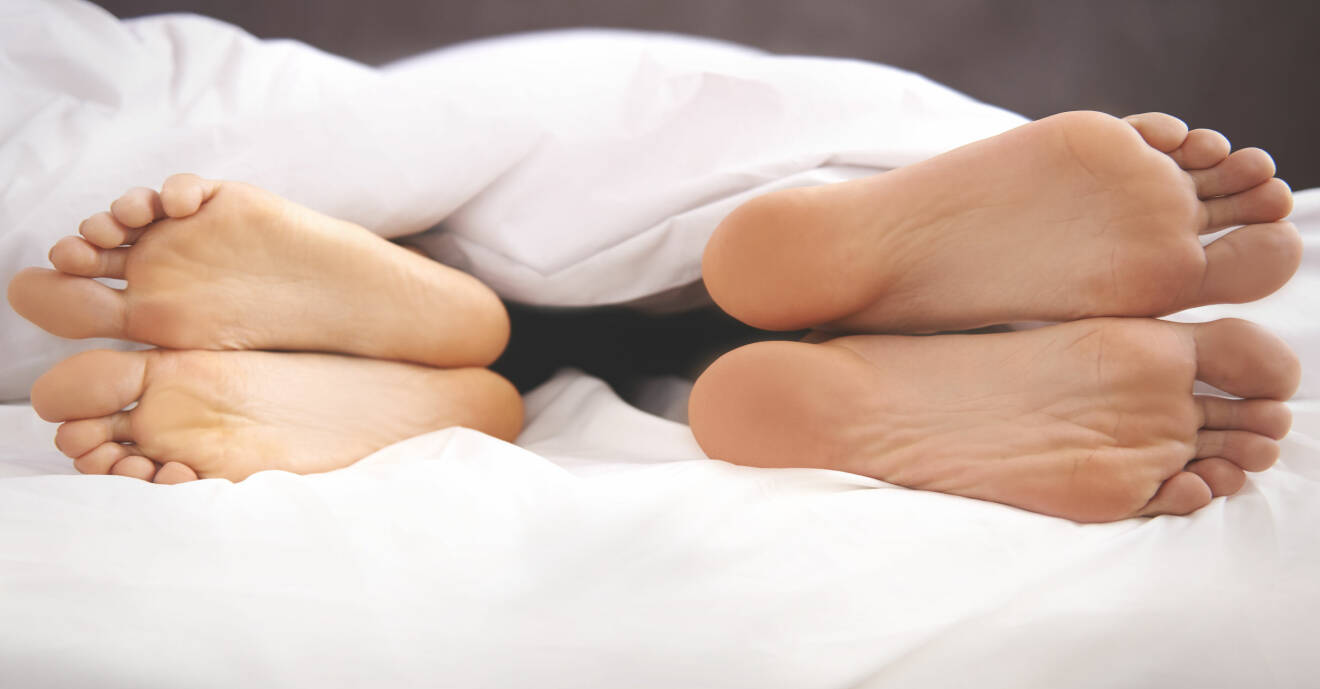Två par fötter i en säng