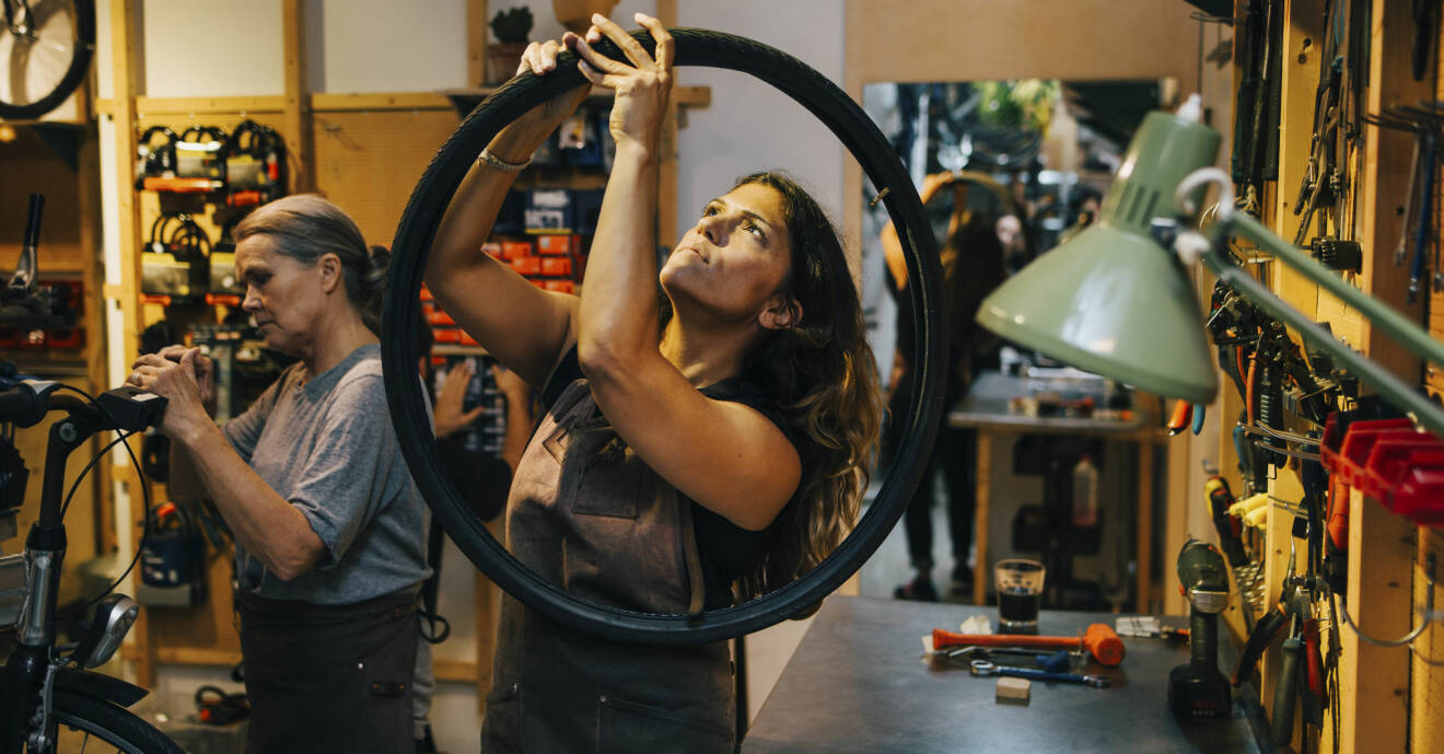 Kvinnliga kollegor lagar cykel i verkstad