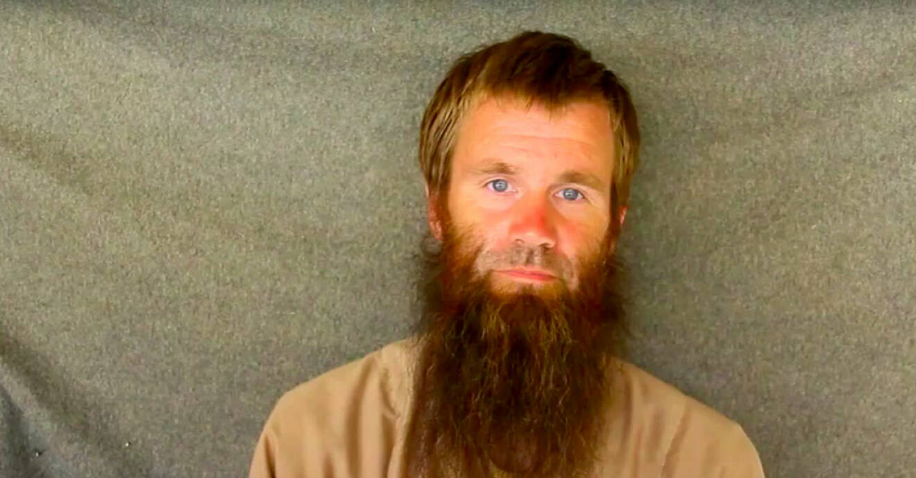 Johan Gustafssonstår mot ett skynke och har långt skägg efter en tids kidnappning i Mali