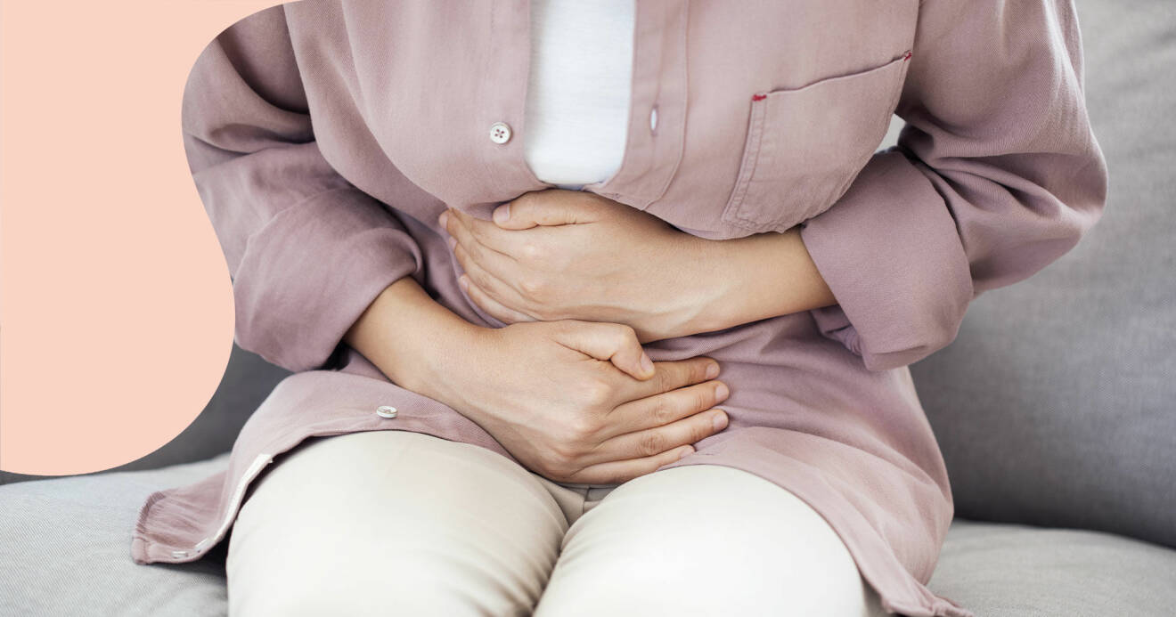 En kvinna med magsmärtor på grund av IBS håller sig för magen.