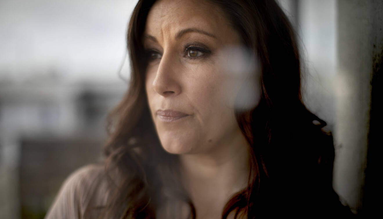 Porträttbild av Lisa Nilsson, taget snett från sidan. Lisa Nilsson har brungröna ögon och långt brunt hår med ett lätt svall.