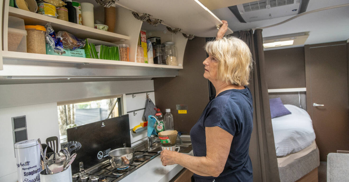 Inger Axelsson visar upp köksskåpen i husvagnen som rymmer allt man kan behöva.