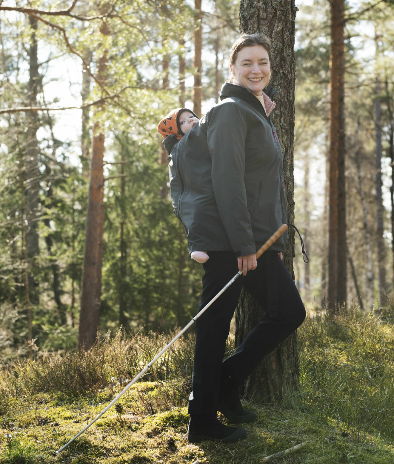 Kristin Nordström ute i skogen tillsammans med sin son Oliver på ryggen.