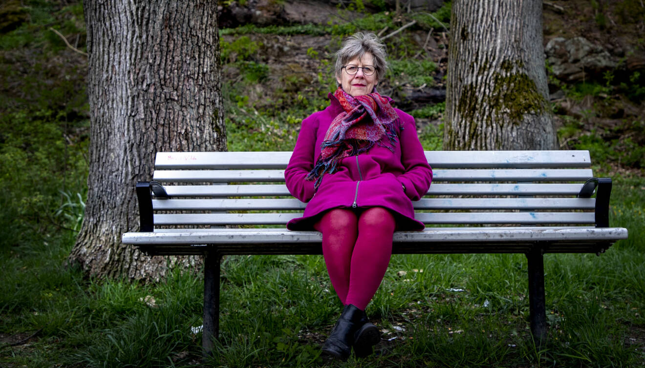 Agnes Wold sitter på en soffa i naturen, klädd i lila och rosa.