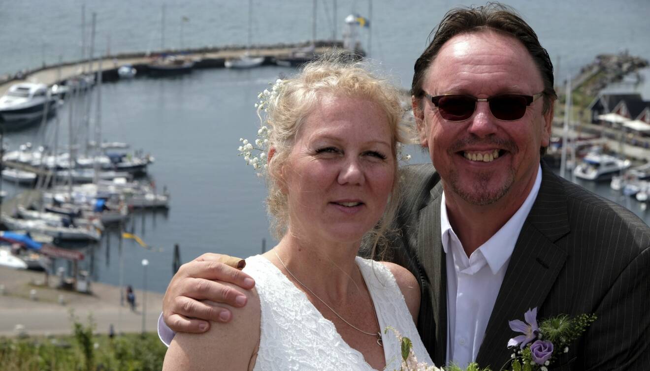 Susanne och Kary står framför hamnen på Ven – ön där de gifte sig 2019.