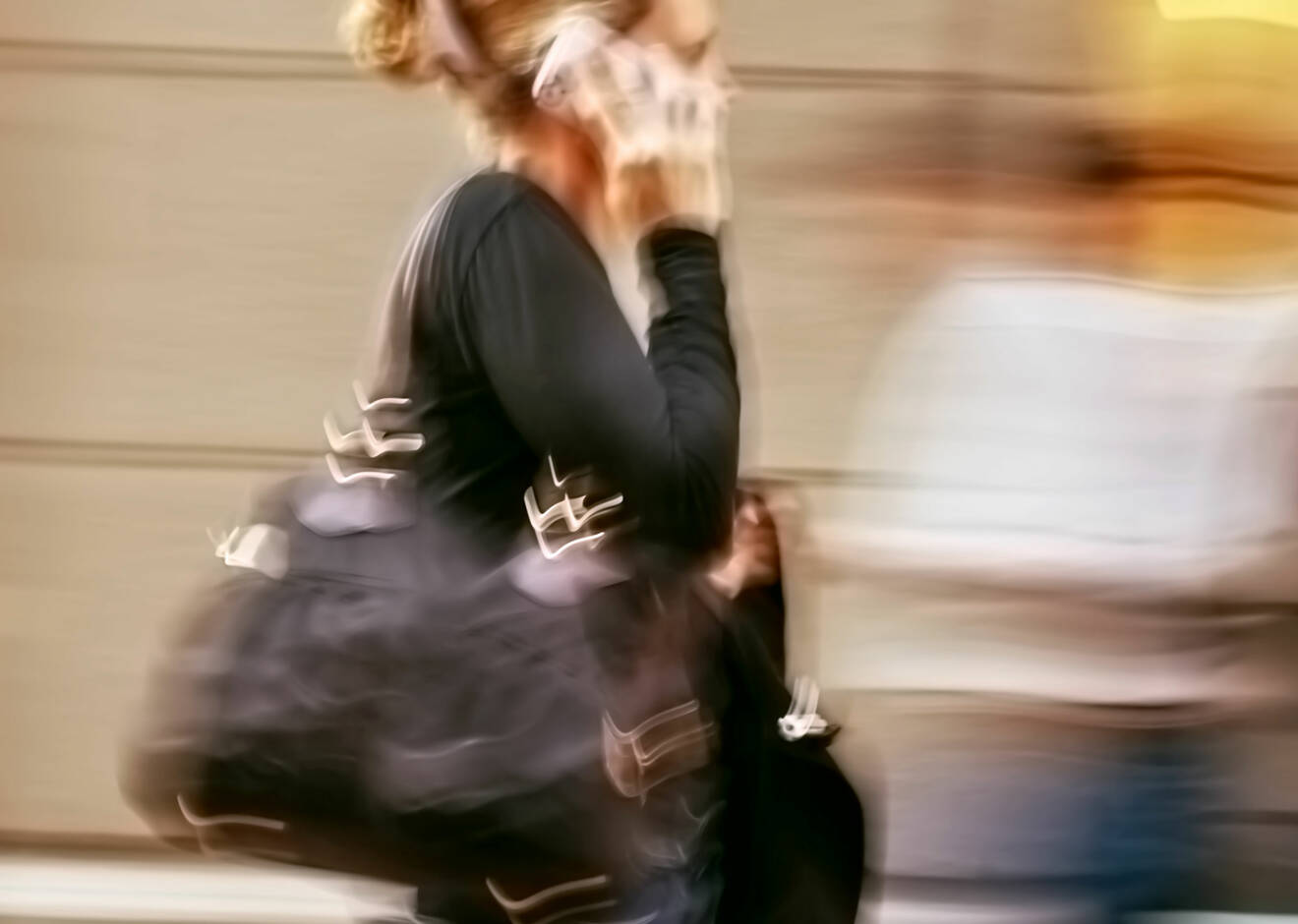 Kvinna talar i mobiltelefon och rör sig snabbt framåt.