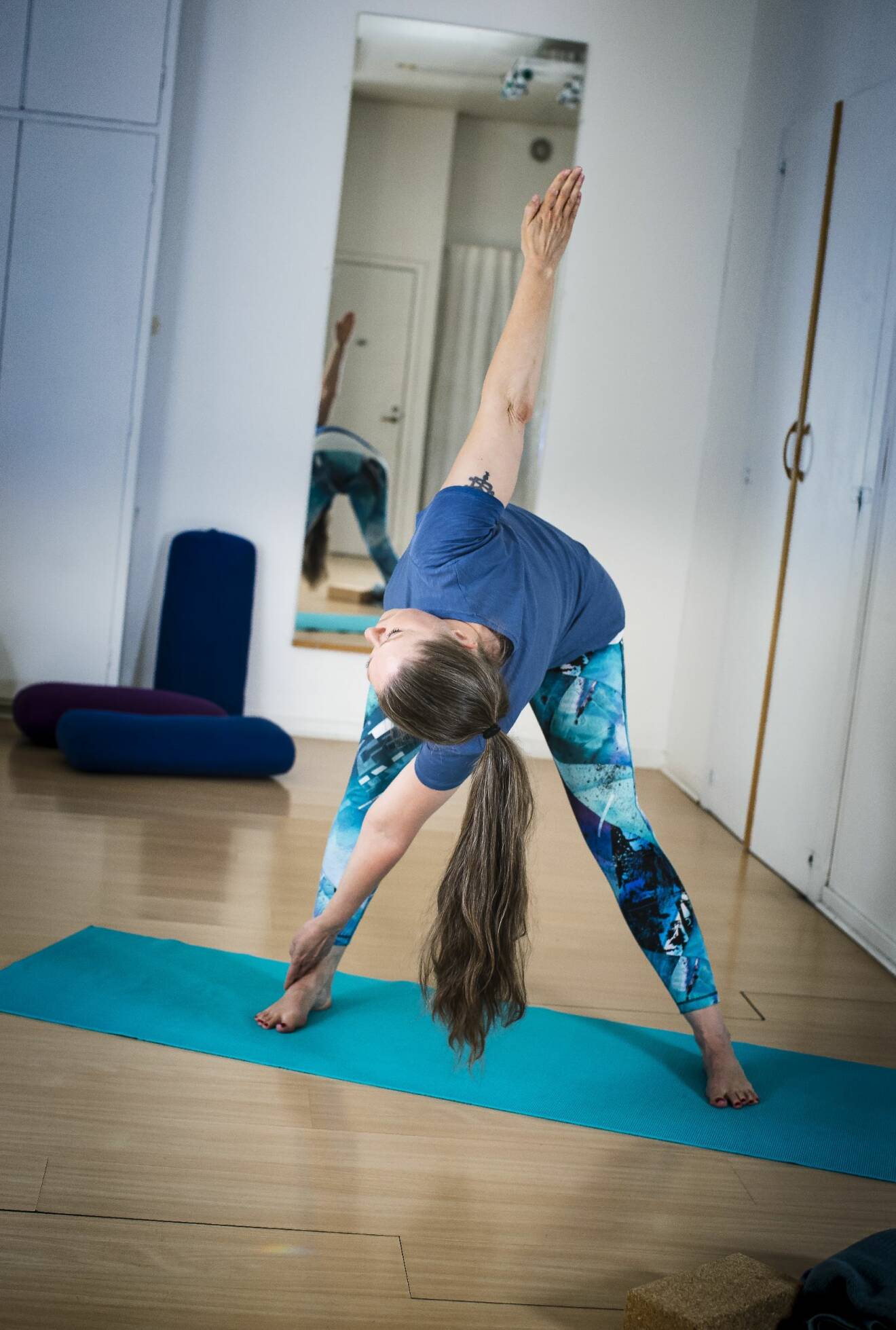 Yogainstruktören Helén Kåselöv rör höger fot med vänster hand.