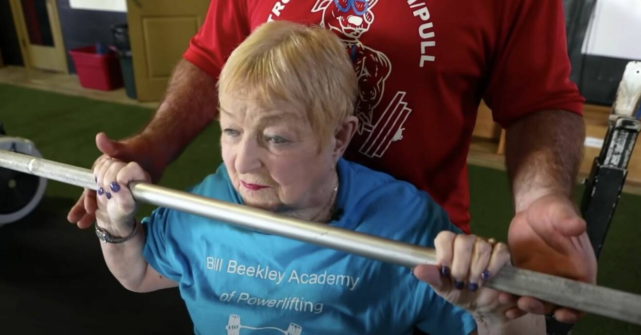 100-årig kvinna styrketränar.