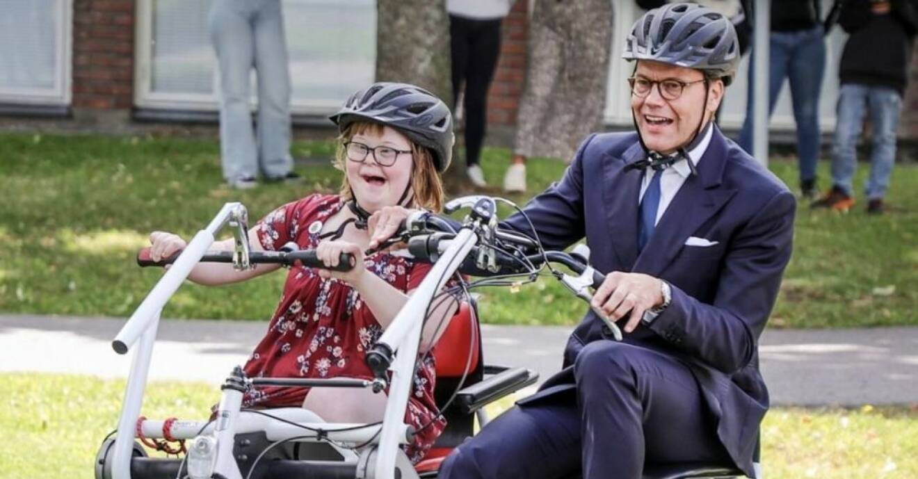 Prins Daniel cyklar på en parcykel tillsammans med en elev.