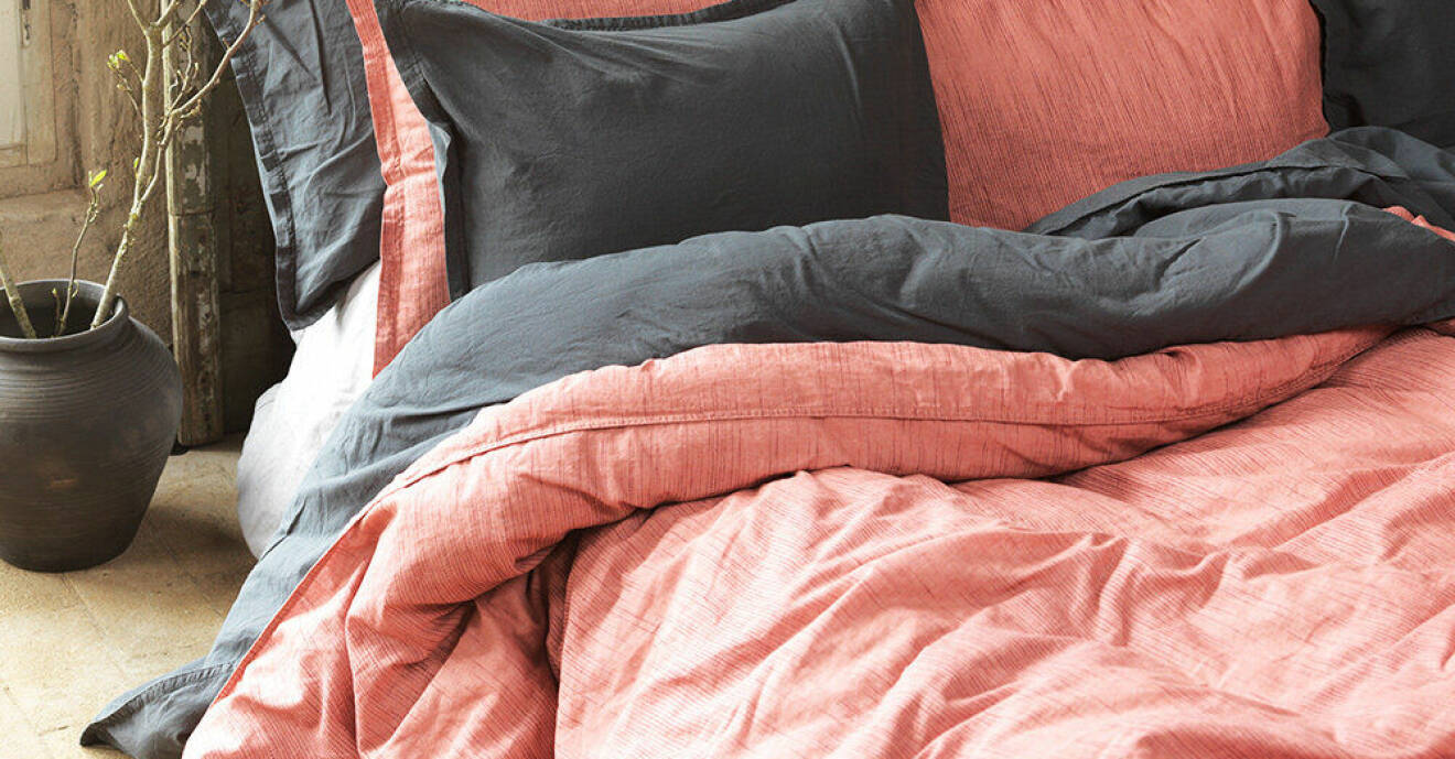 Gråa och aprikosa sängkläder i en säng.
