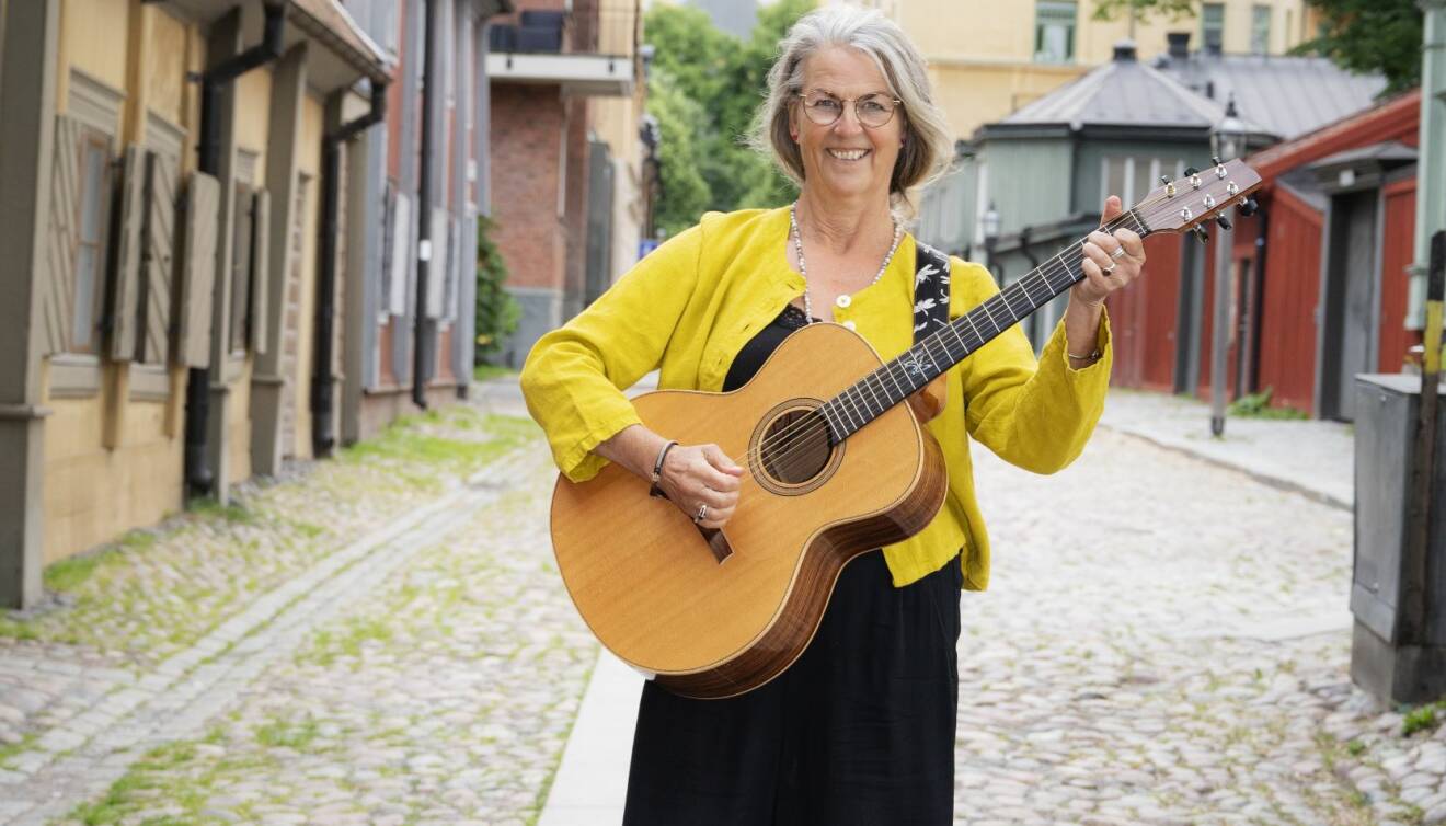 Mona Johansson står på gatan, tar ett ackord på sin gitarr och berättar om hur hon gick i pension vid 61-års ålder för att satsa på musiken, en dröm hon haft sedan barndomen.