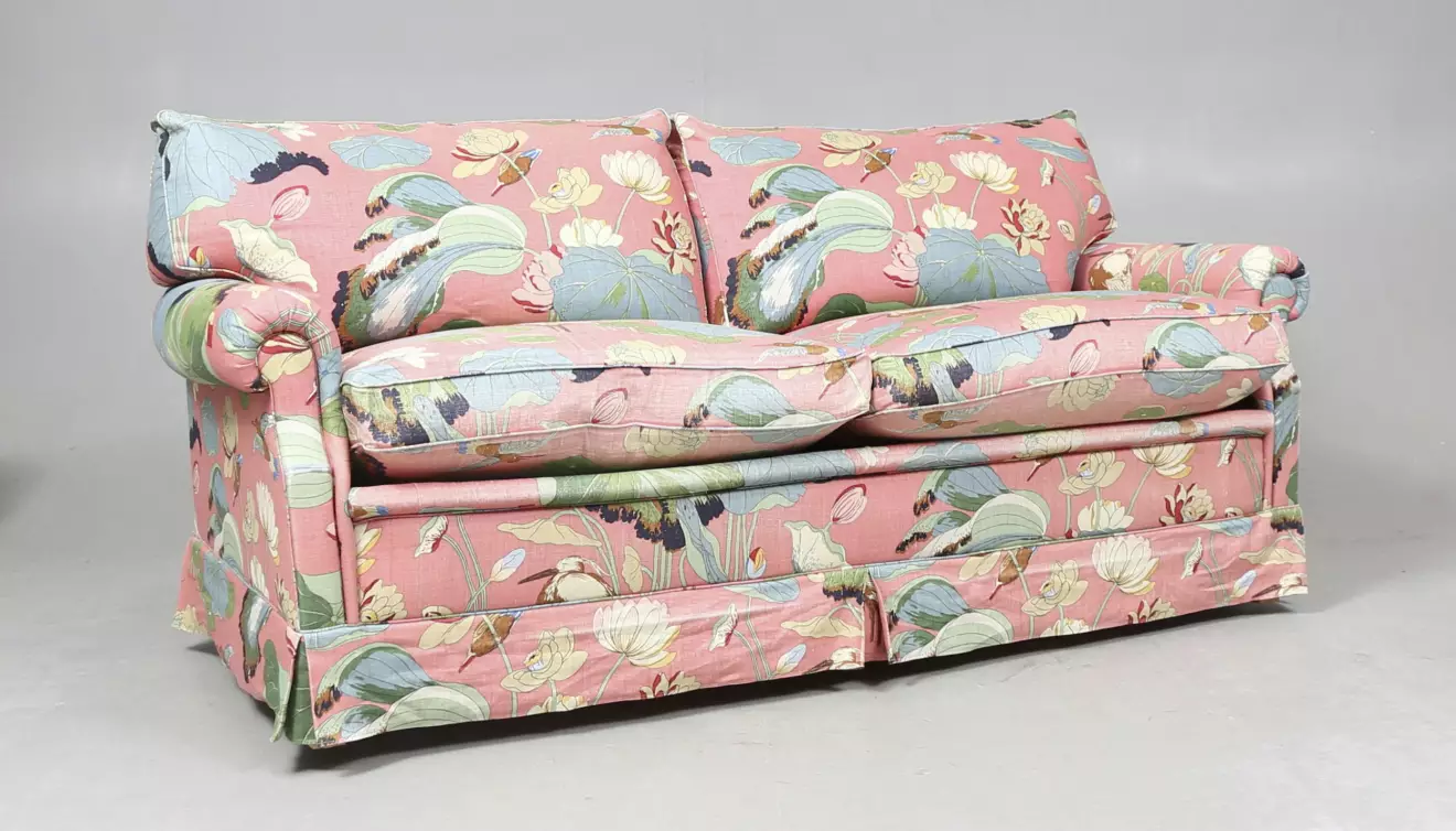 Rosa soffa med mönster i ljusa färger.