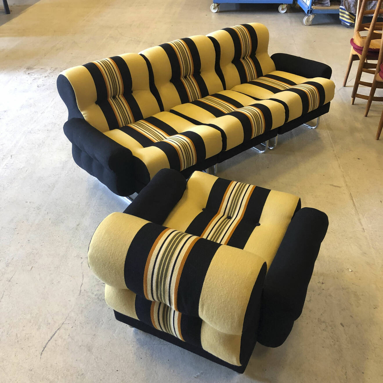 En tresitsig soffa och en fåtaölj i gult- och svartrandigt tyg.