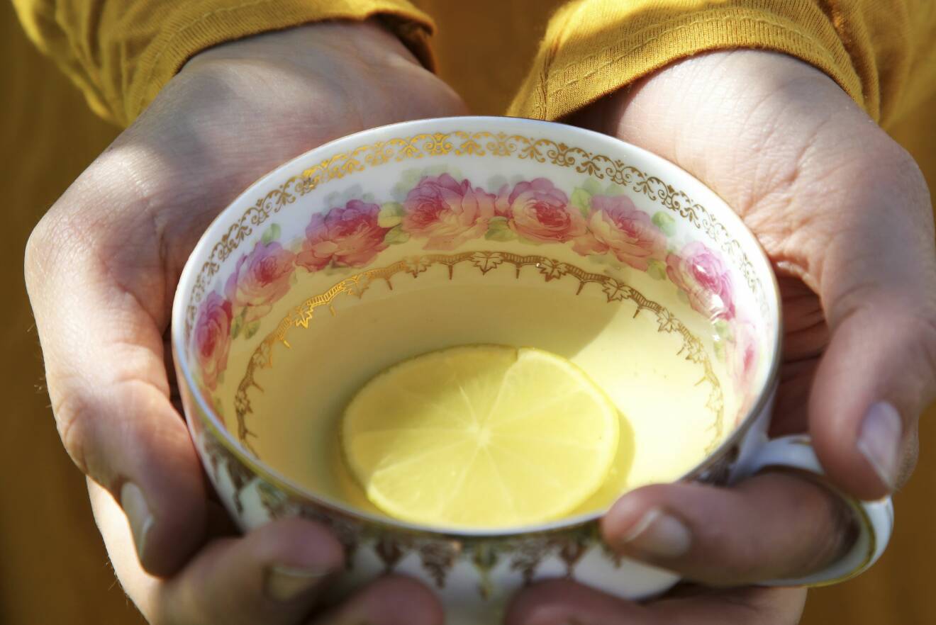 En kopp kamomillte med en citronskiva.