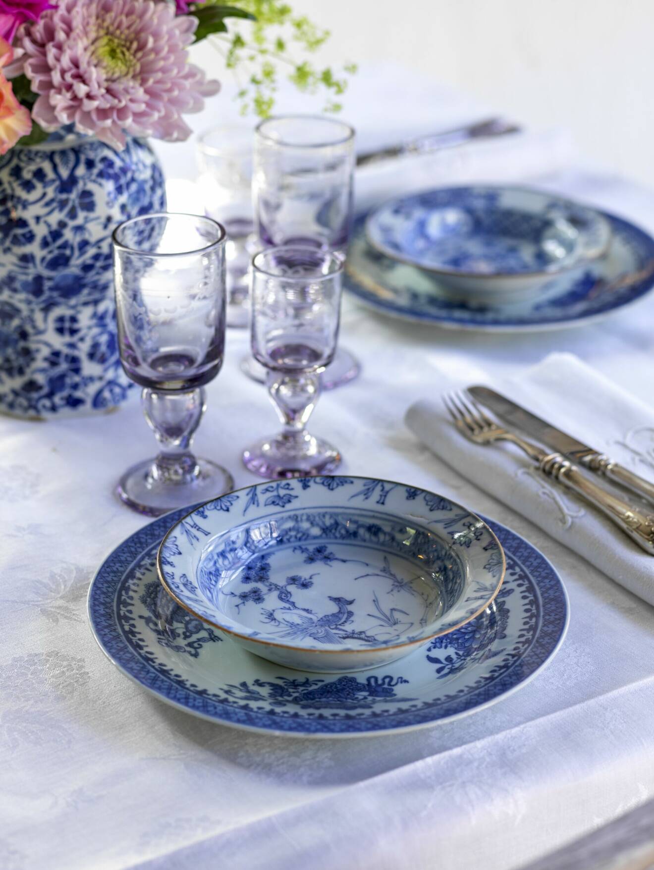 Bord dukat i gustaviansk stil med blåvit servis och kruka med stor blombukett.
