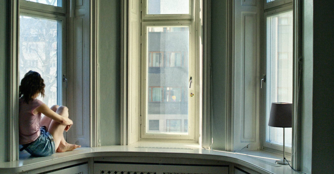 En kvinna sitter i ett burspråk i en lägenhet. Bilden är hämtad ur SVT-serien En kropp till salu.