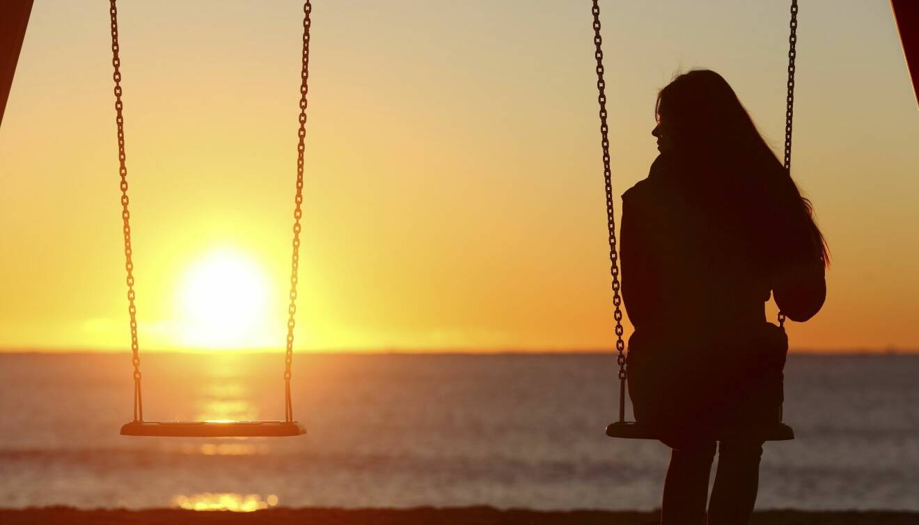 Kvinna sitter ensam vid havet, och funderar över framtiden och framtidsfullmakt.