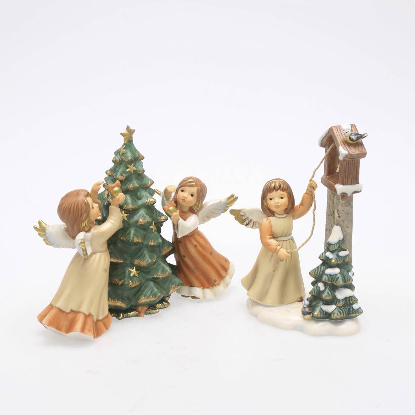 Två figuriner med änglar och julgranar.