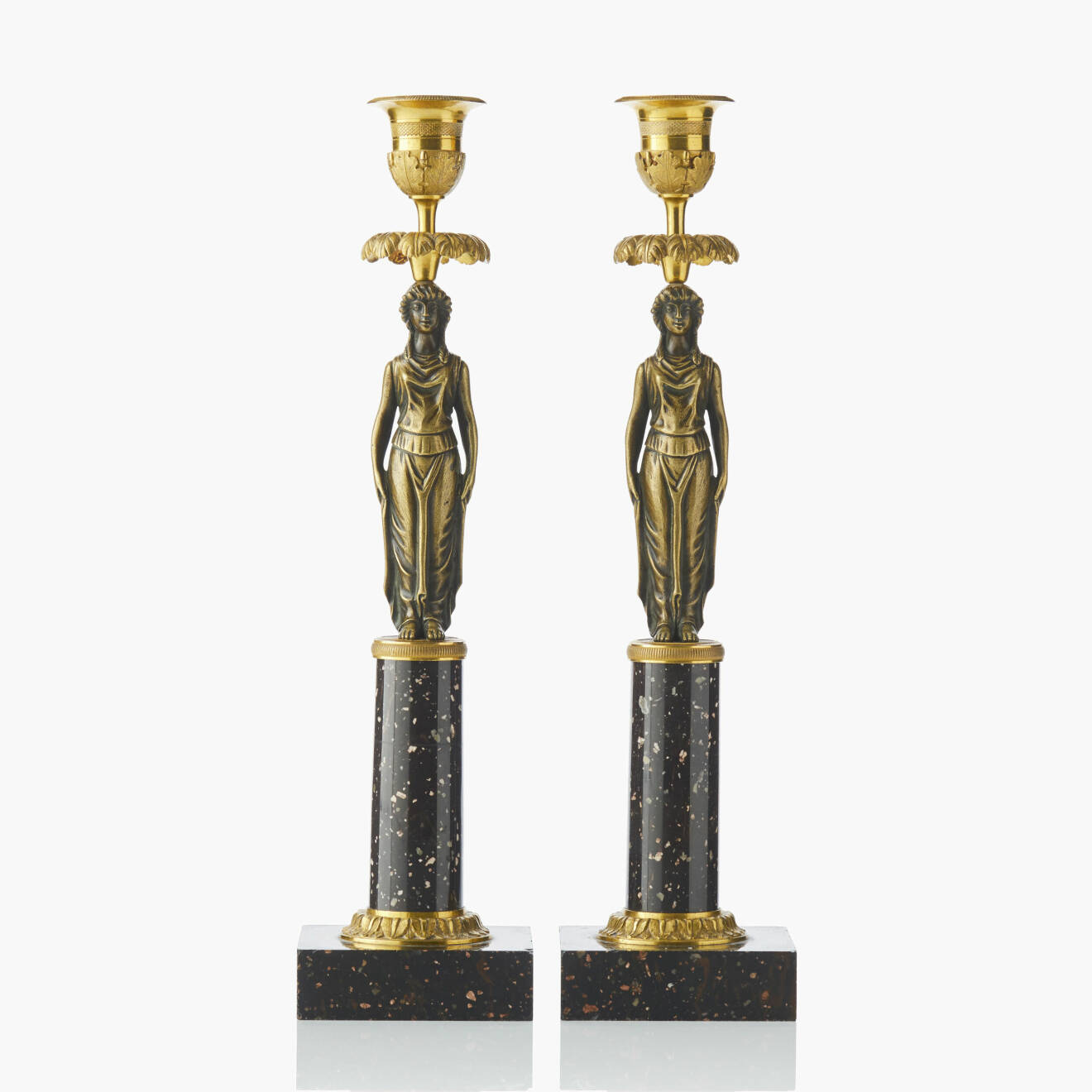 Två sengustavianska ljusstakar i kolonnmodell med skaft i form av antikiserade kvinnofigurer av brons.