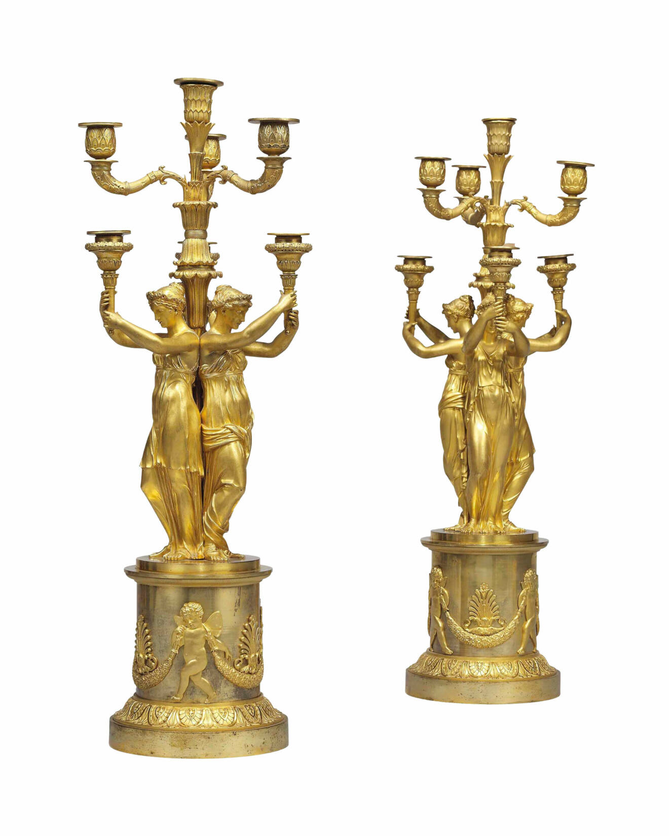 Två kandelabrar i förgylld brons där kvinnor bär upp ljusen.