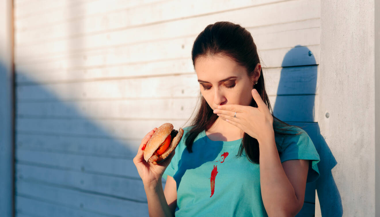 Kvinna spiller ketchup på sin tröja