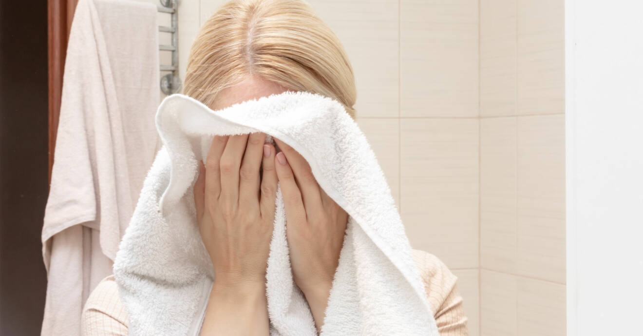 Kvinna torkar ansiktet på en handduk