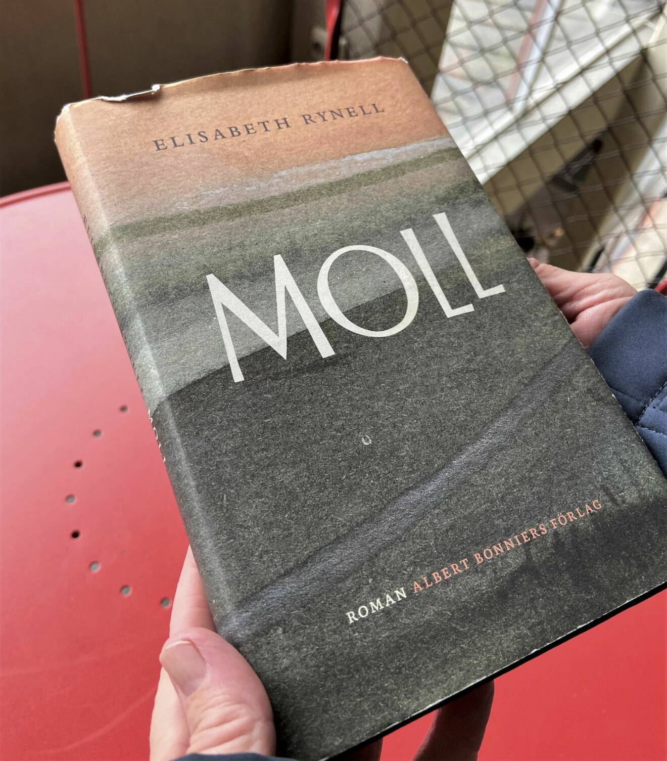 Elisabeth håller fram boken Moll, som är hennes senaste roman.
