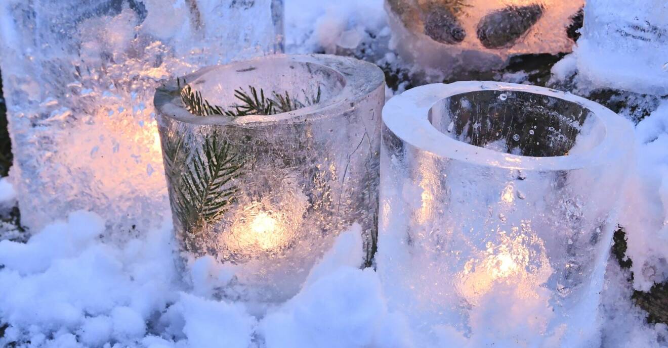 Ljuslyktor gjorda av is utomhus i snön.