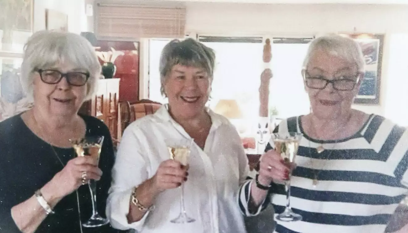 De tre systrarna Margaretha, Ann-Kristin och Marianne står bredvid varandra och håller var sitt vinglas i händerna.