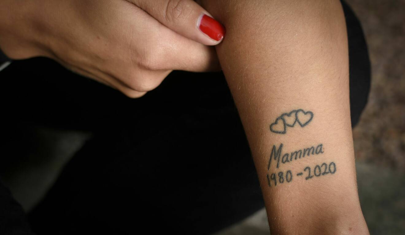 Julia visar upp tatueringen på armen med tre hjärtan och texten Mamma 1980 - 2020.