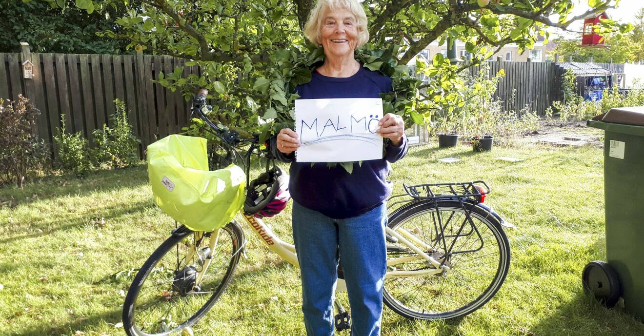 Jeannet har nått Malmö efter en tre veckor lång cykeltur i Sverige och stå framför sin cykel och håller en skylt framför bröstet där det står Malmö.