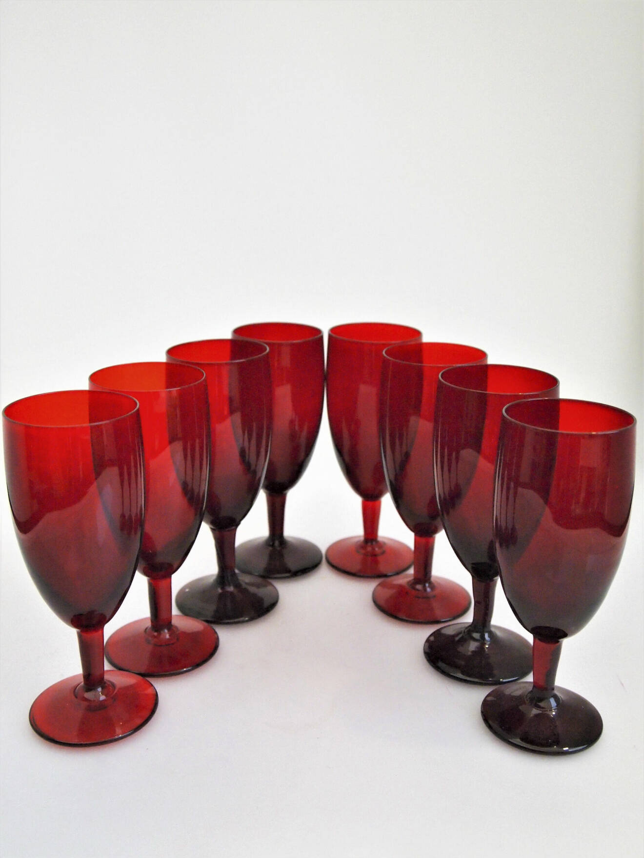 Monica Bratt började på Reijmyre glasbruk 1937 och blev kvar där i drygt 20år. Hon byggde upp en helt egen kollektion och gjorde stora insatser för bruket. De rubinröda glasen är bland hennes mest kända skapelser. Höjden är 15cm. 450kr för åtta glas på Lysekils Auktionsbyrå.