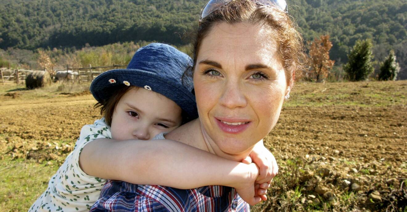 Catrin Kylberg med sin cancersjuka dotter Leia på ryggen.