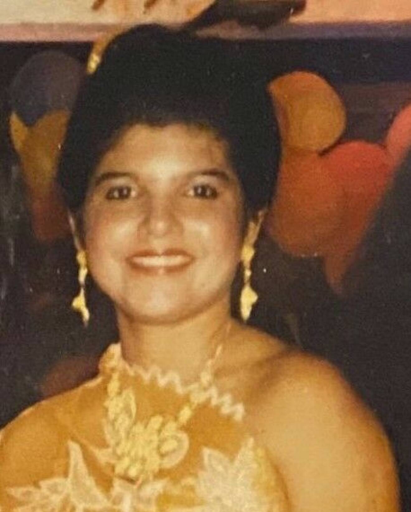 Yolanda som ung, iförd gul festklänning.