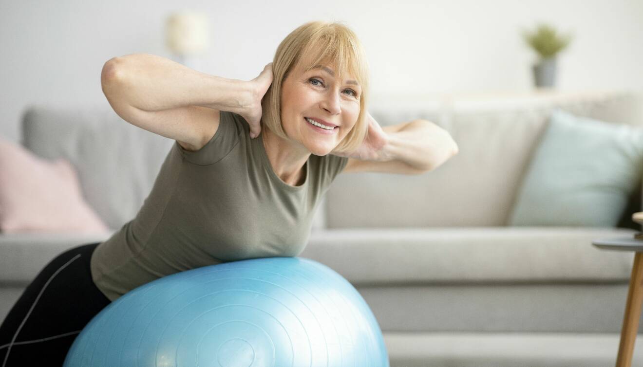 Kvinna tränar med pilatesboll, det kan hjälpa i klimakteriet.