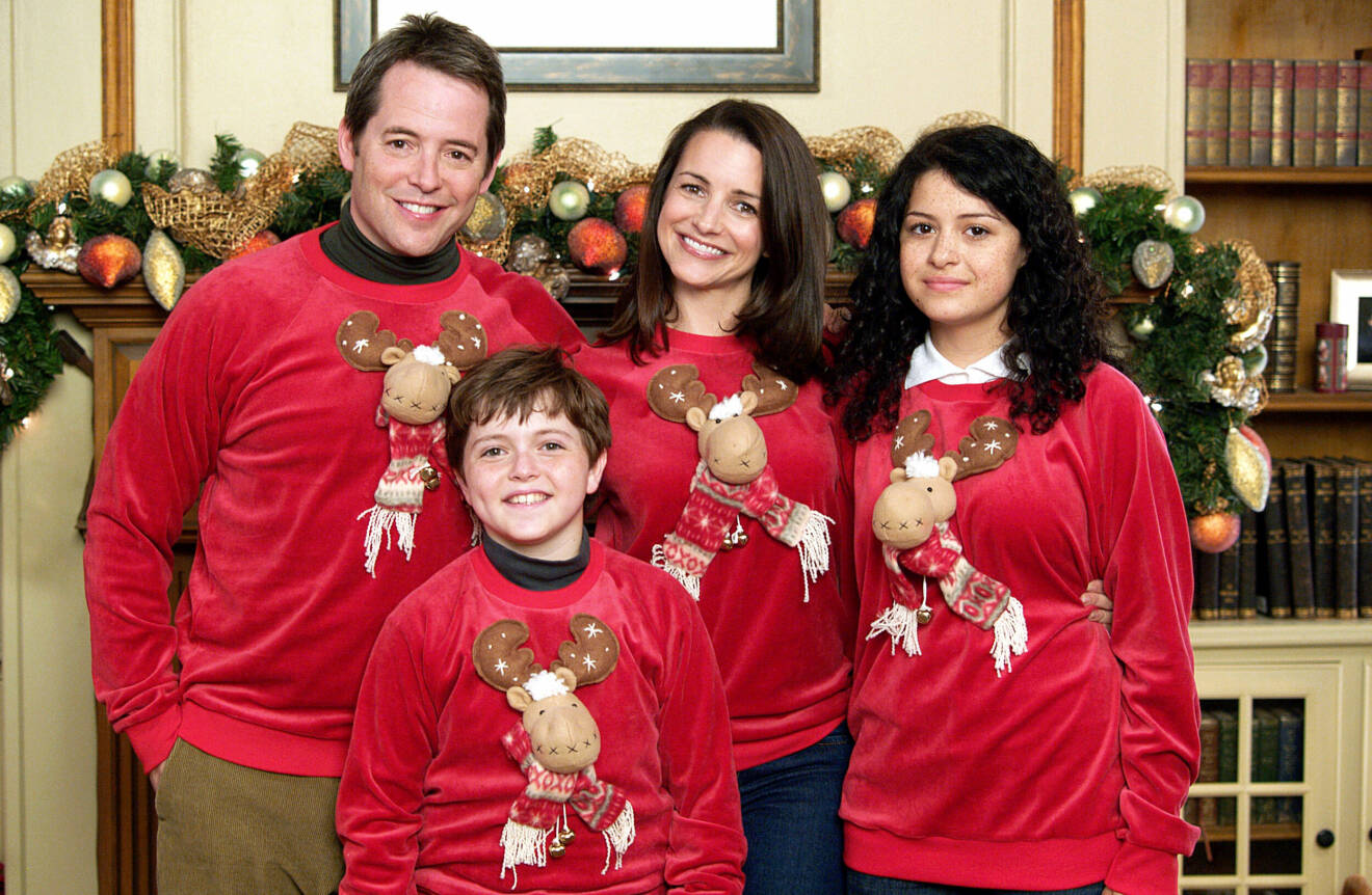 Fyra personer i jultröjor med älgar på.
