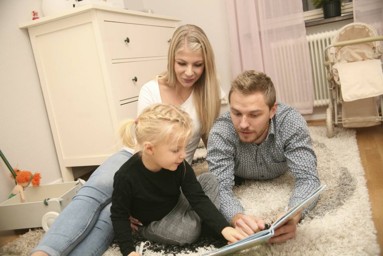 Drygt tvååriga Haylie på sitt rum tillsammans med mamma Nellie och pappa Hannes, som läser saga.