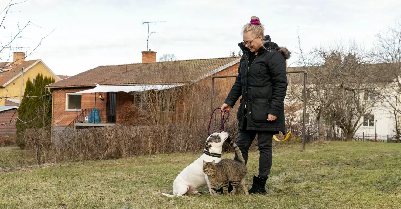 Johanna Brinck tillsammans med sin hund och katt utanför huset i Vingåker.