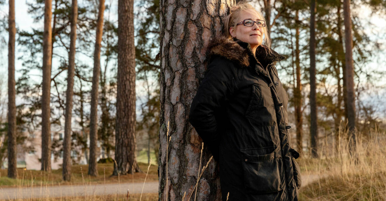 Johanna Brinck står lutad mot ett träd i hemstaden Vingåker.