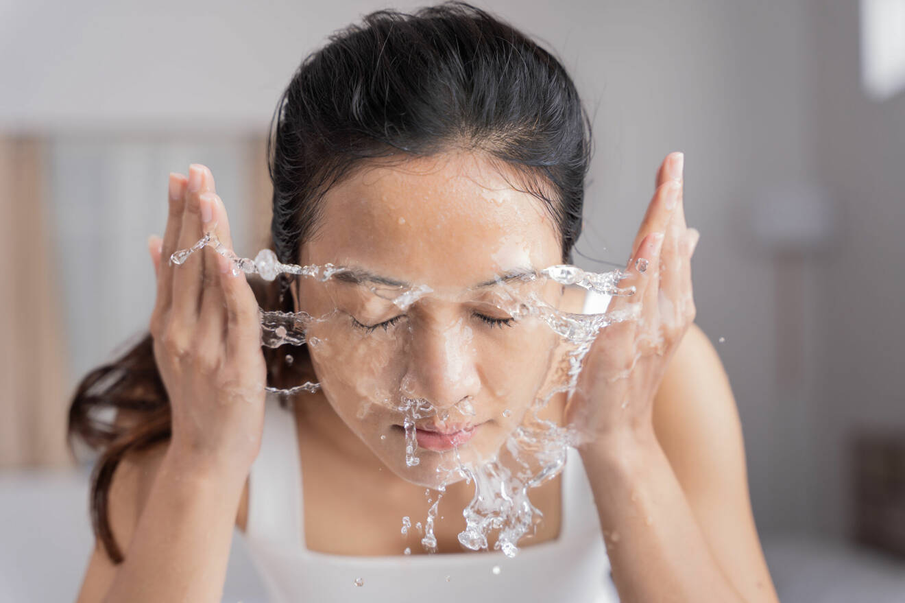 Kvinna tvättar ansiktet.