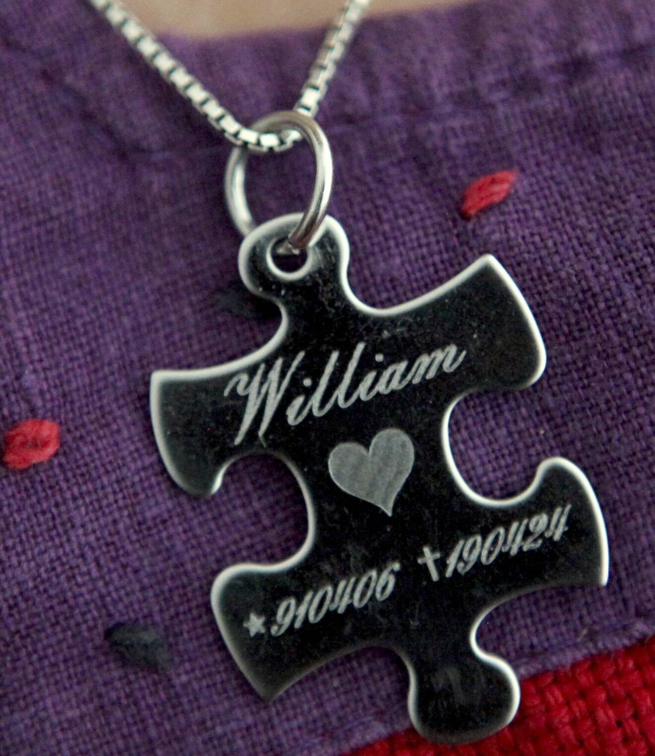 Runt halsen bär Susanne ett smycket som ser ut som en pusselbit och där det står William och hans personnummer.
