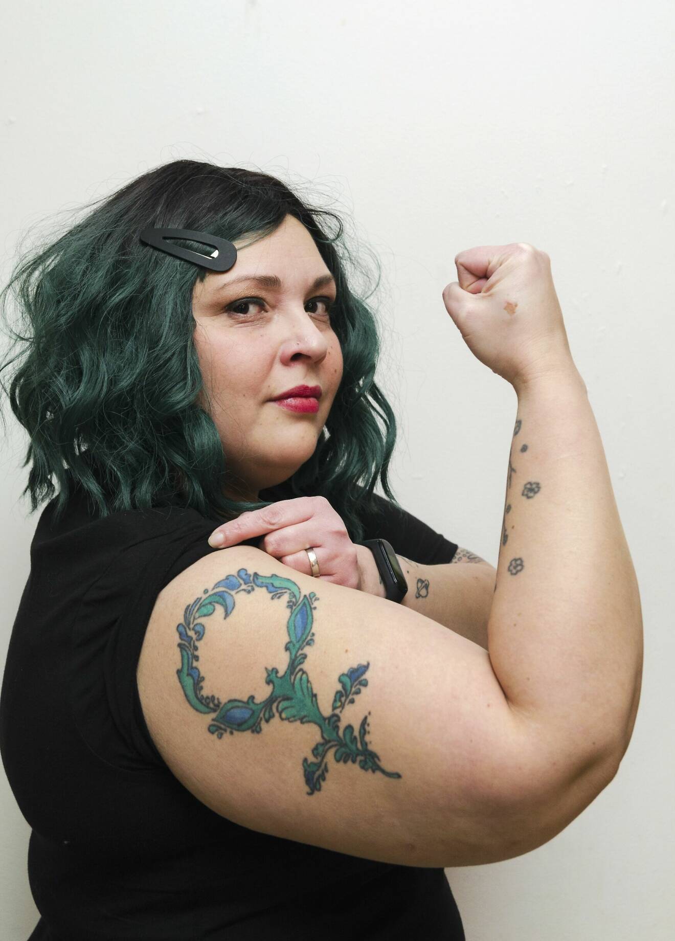 Arlene Stridh spänner musklerna och har en tatuering på överarmen med kvinnosymbolen.