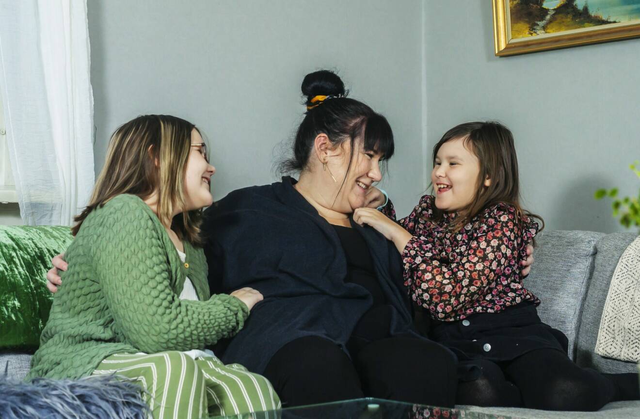 Rebecca Karlsson Andersson busar i soffan med döttrarna Emma och Elly Broström Andersson.