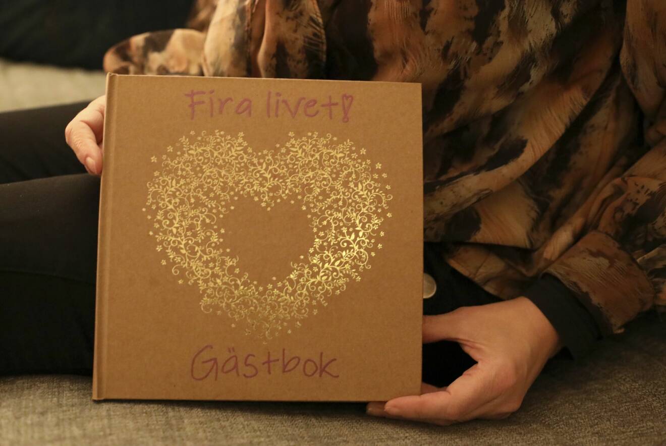 Gästboken från festen pryds av ett guldigt hjärta. Ovanför hjärtat står det: Fira livet!